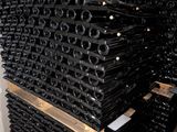 many bottles of wine stacked on a pallet in a room