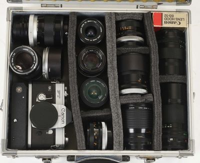 many cameras in a case that is sitting on a table