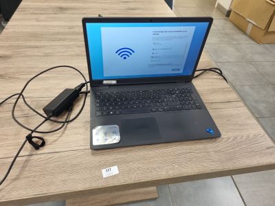 un ordinateur portable posé sur une table avec un chargeur