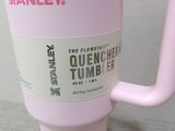a pink coffee cup with a handle on a table