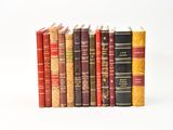 several books are stacked on top of each other on a white surface