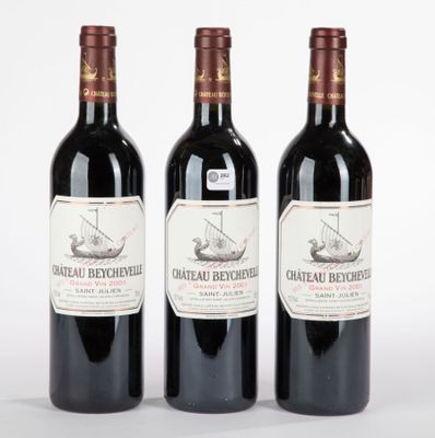 trois bouteilles de vin rouge posées l'une à côté de l'autre sur une surface blanche
