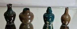 cinq vases alignés sur une étagère