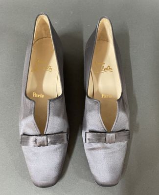 pair of women ' s grey shoes with bows on the toes