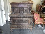 a wooden chest sitting in a room next to a chair