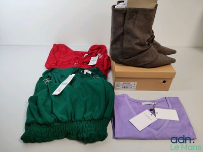 Trois paires de bottes pour femmes et un t-shirt sont posés sur une table