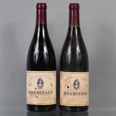 deux bouteilles de vin rouge sont posées l'une à côté de l'autre sur une table
