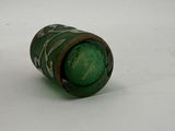 a green bottle that is sitting on a white surface