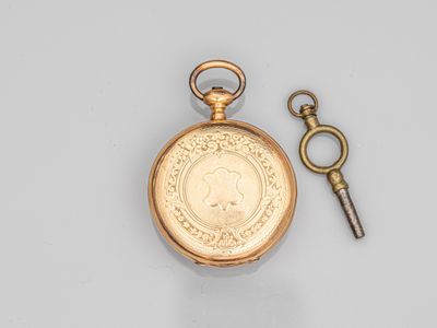 une montre de poche en or ancien à laquelle est attachée une clé