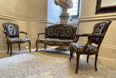 trois chaises et un canapé dans une pièce avec une statue en arrière-plan