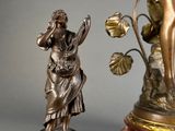 a statue of a woman holding a flower next to a statue of a man