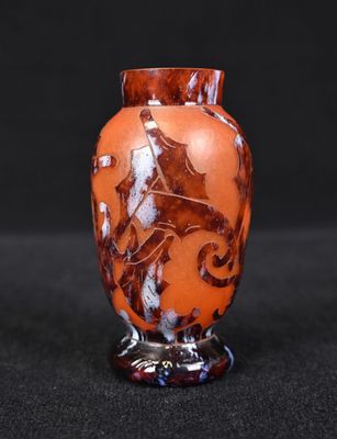 an orange vase with a horse on it on a black surface