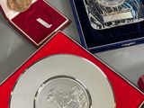 a silver coin in a red box next to other silver coins