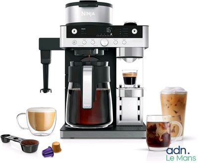 a coffee maker with a cup of coffee next to it