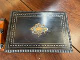 a black and gold box sitting on a wooden table