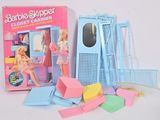 une poupée Barbie et un ensemble d'accessoires posés sur la table