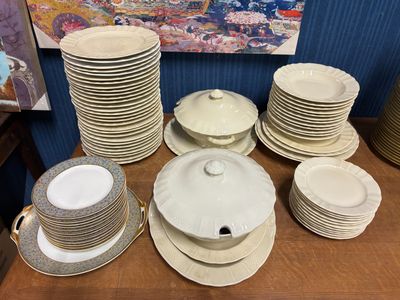 de nombreuses assiettes et bols posés sur une table, avec un tableau en arrière-plan