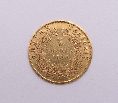 gros plan d'une pièce d'or sur une surface blanche