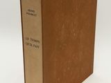an old book sitting on top of a white table next to a white wall