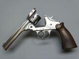 a close up of a revolver with a wooden handle on a gray surface