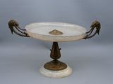 a white marble pedestal with a bird handle on it