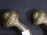 pair of antique walking canes on a black background with a price tag