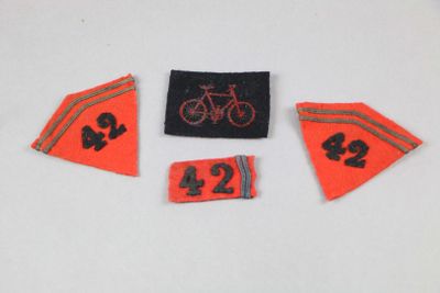 trois pastilles sur fond blanc, sur lesquelles figurent des chiffres et un vélo
