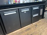 a black counter top with two drawers and two doors