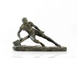 statue d'un homme tenant un marteau, posée sur une surface blanche