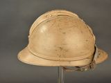 an old helmet on a stand on a gray background