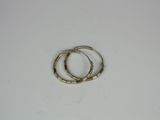 pair of gold tone bamboo bracelets on a white surface