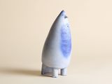 un petit objet bleu et blanc posé sur une surface blanche