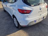 the rear end of a white car parked in front of a garage