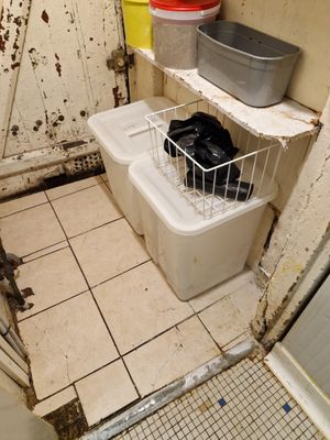 une salle de bains sale avec des toilettes et une poubelle à l'intérieur