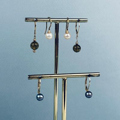 un présentoir en métal auquel sont suspendues trois paires de boucles d'oreilles