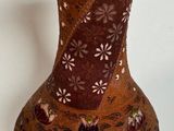 a brown vase that is sitting on a white surface