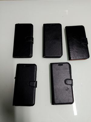 Quatre téléphones portables sont alignés sur une table blanche