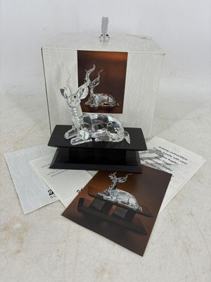 une sculpture en verre représentant un cerf, posée sur une table