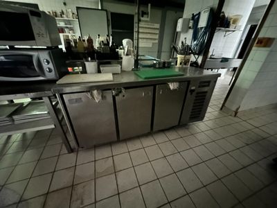 une cuisine avec beaucoup de plan de travail et un micro-ondes