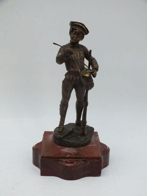 statue en bronze représentant un homme tenant un fusil, posée sur un socle en bois