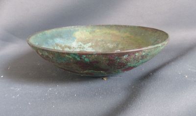 un bol vert posé sur un tissu gris