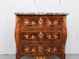 une commode ancienne avec un plateau en marbre et des détails dorés
