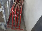 Plusieurs battes de baseball sont appuyées contre un mur dans un garage.