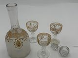 three wine glasses and a decanter sitting on a table