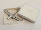 a small silver airplane in a box on a table