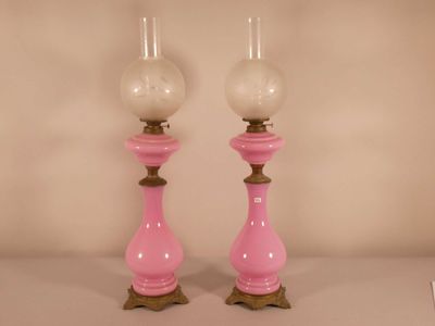 une paire de bougeoirs en verre rose posés sur une table