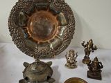 une assiette en argent et d'autres objets en métal posés sur une table