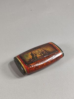 une petite bouteille ornée d'une image, posée sur une table