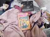 a pile of clothes and a book on a bed
