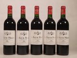quatre bouteilles de vin rouge sont alignées sur une table